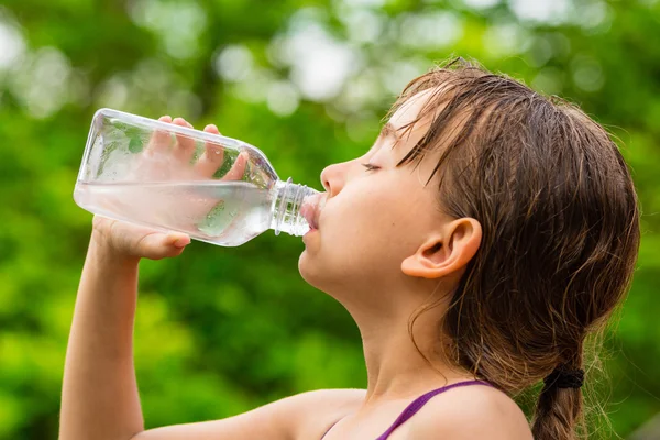 Bambino che beve acqua di rubinetto pulita dalla bottiglia di plastica trasparente — Foto Stock