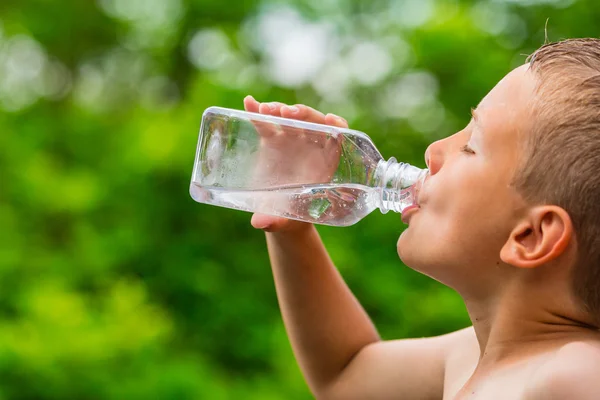 Boy drinking clean tap water from transparent plastic bottle — Stock Photo, Image