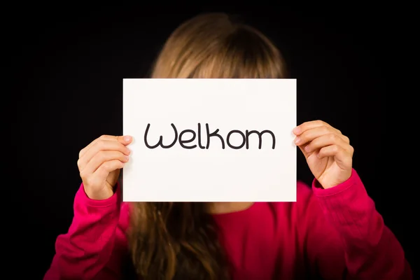 Kind hält Schild mit holländischem Wort welkom - willkommen — Stockfoto