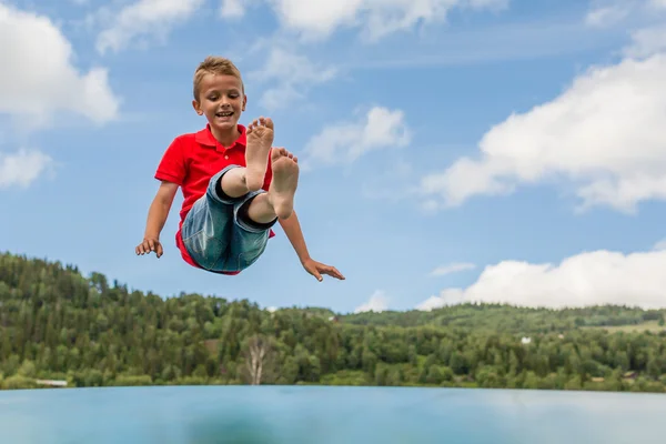 Ung pojke hoppar på studsmatta — Stockfoto