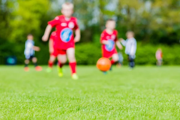 Blurred kids playing youth football match — Stock Photo, Image