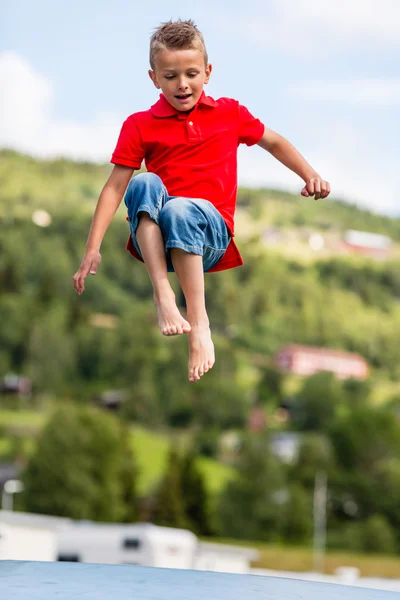 Jonge jongen springen op de trampoline — Stockfoto