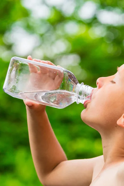 Giovane ragazzo che beve acqua dalla bottiglia — Foto Stock