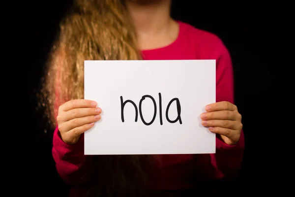 Child holding sign with Spanish word Hola - Hello — Stock Photo, Image