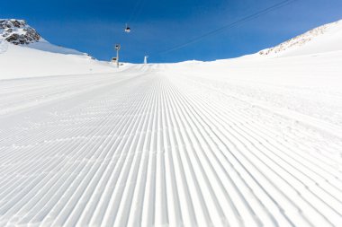 Güneşli bir günde yeni bakımlı kayak pisti
