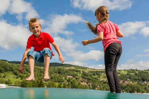 Barnen hoppar på bouncy kudde — Stockfoto