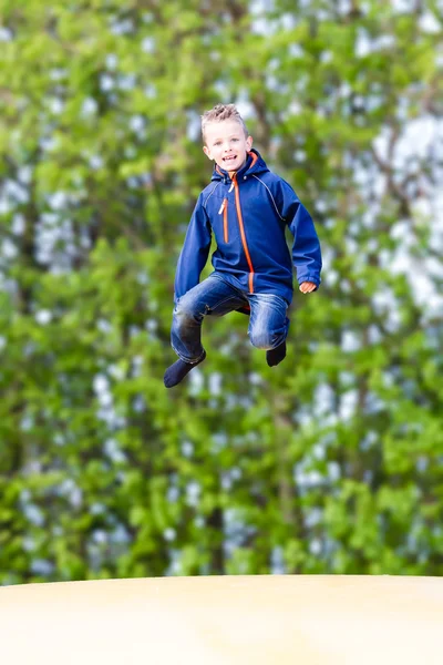 Szczęśliwy chłopiec skoki na trampolinie — Zdjęcie stockowe