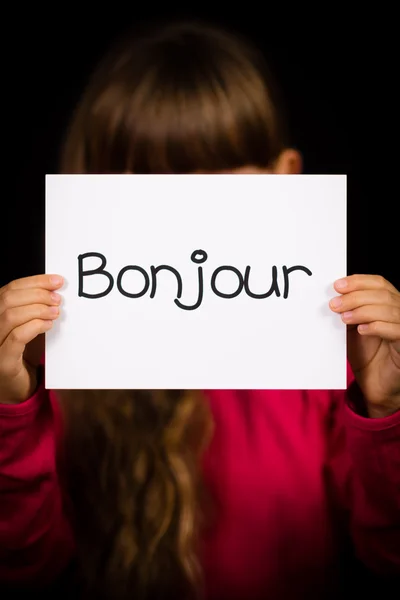 Ребенок держит табличку с французским словом Bonjour - Hello — стоковое фото
