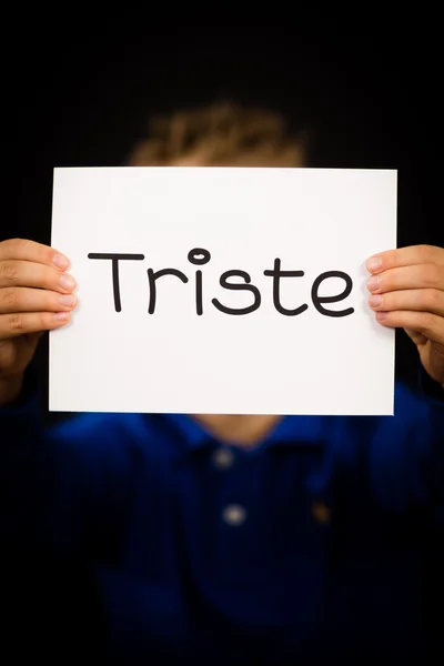 Child holding sign with Spanish word Triste - Sorry — Stock Photo, Image