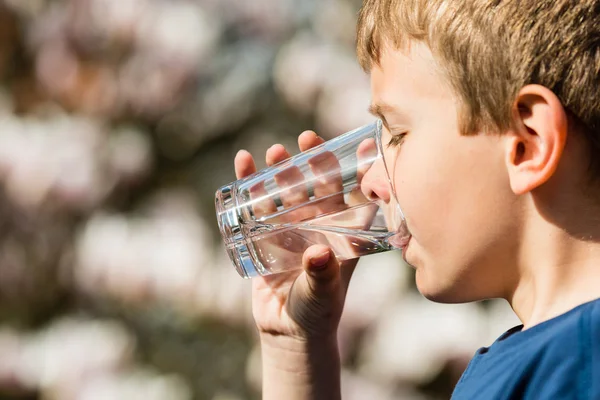 Chłopiec trzyma szklankę wody słodkiej — Zdjęcie stockowe