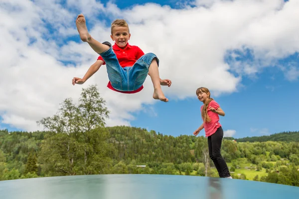 Kinderen springen op het springkussen kussen — Stockfoto