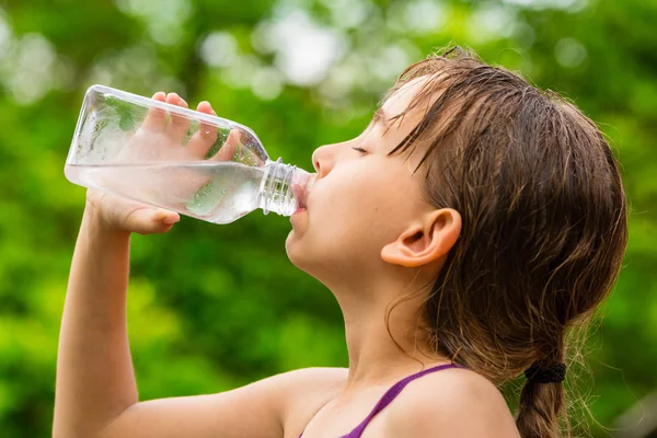 Child drinking clean tap water from transparent plastic bottle — Stock Photo, Image