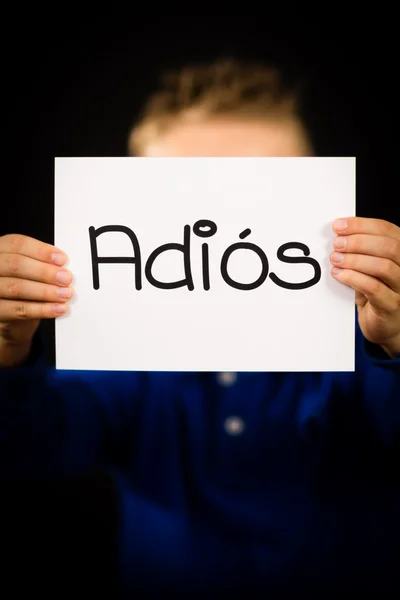 Bambino che tiene il segno con la parola spagnola Adios - Addio — Foto Stock