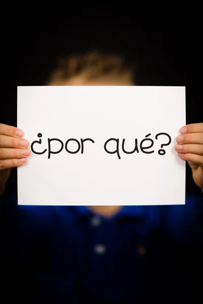 Kind hält Schild mit spanischen Wörtern por que - warum — Stockfoto