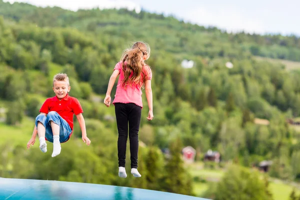Les enfants rebondissent de haut en bas sur le trampoline — Photo