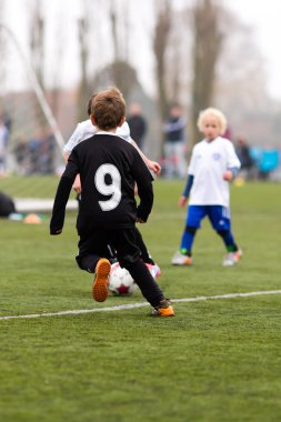 Yapay sahada futbol oynayan çocuklar