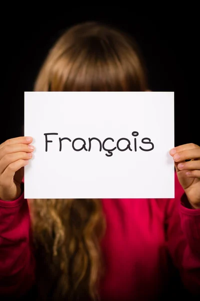 Дитина тримає знак з французьким словом Francais - Французька — стокове фото