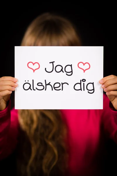 Dziecko trzyma znak ze szwedzkim słowa Jag Alsker Dig - I Love Yo — Zdjęcie stockowe