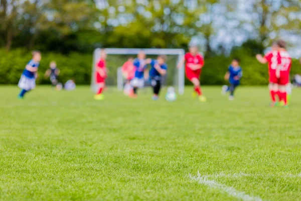 Bambini sfocati che giocano partita di calcio giovanile — Foto Stock