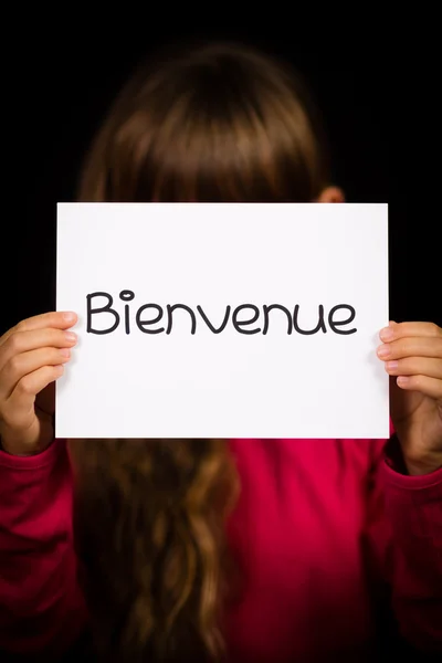 Gyermeke tartja a jele, a francia szó Bienvenue - Üdvözöljük — Stock Fotó