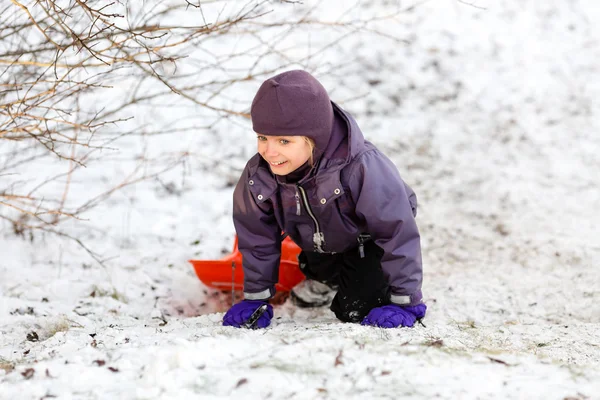 Ragazza che gioca con la slitta nella neve invernale — Foto Stock