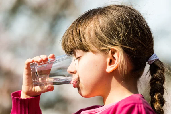 Ragazza che beve acqua dal vetro — Foto Stock