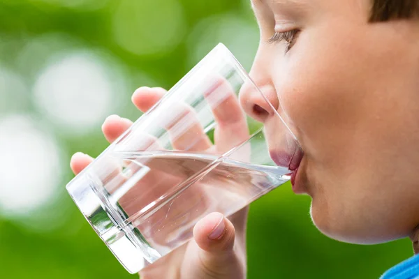 Pojke dricka friskt vatten ur glas — Stockfoto