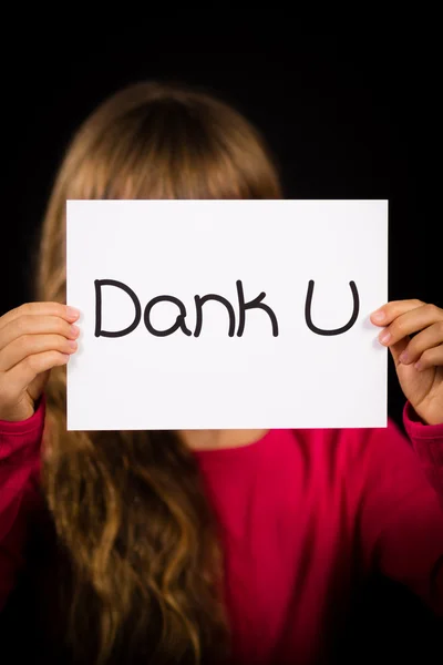 Dziecko trzyma znak z holenderskiego słowa Dank U - dziękuję — Zdjęcie stockowe