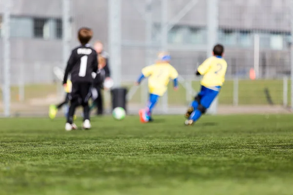 Crianças desfocadas jogando futebol — Fotografia de Stock