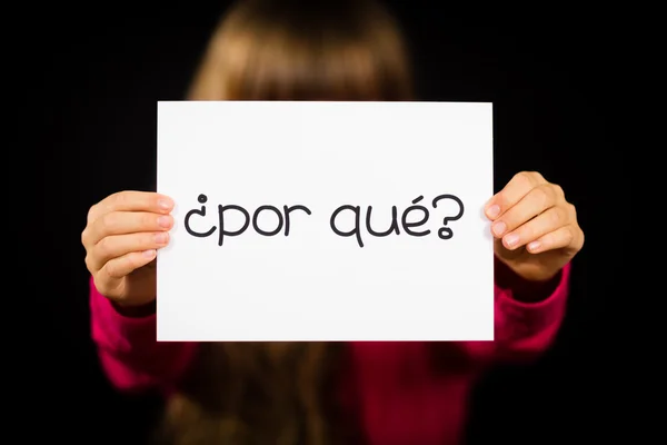 Kind hält Schild mit spanischen Wörtern por que - warum — Stockfoto