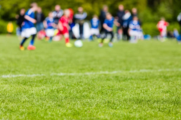 Bambini sfocati che giocano partita di calcio giovanile — Foto Stock