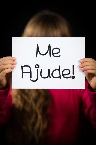 Child holding sign with Portuguese words Me Ajude - Help Me — Stock Photo, Image