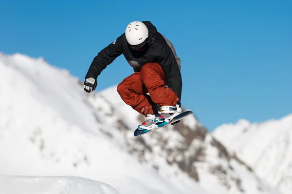 Snowboarder saut dans le snowpark — Photo