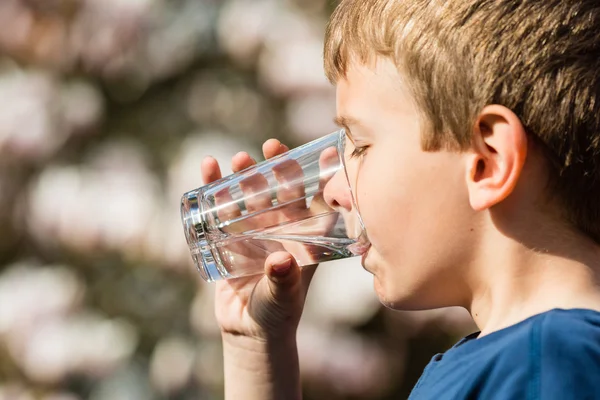 Pojke dricka friskt vatten ur glas — Stockfoto