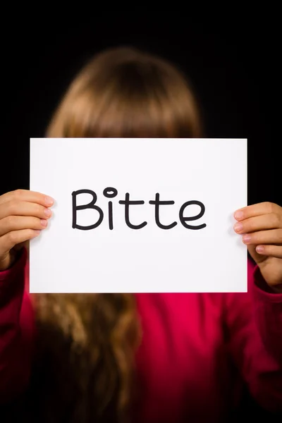 Ребенок держит в руках табличку с немецким словом Озил - пожалуйста — стоковое фото
