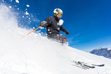 Skier skiing on ski slope clipart