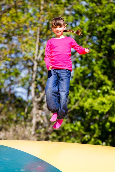 Lykkelig pige på trampolin - Stock-foto