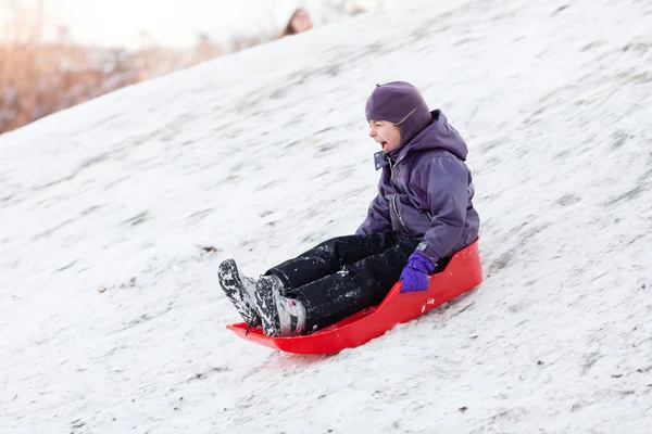 Bambino che gioca con la slitta nella neve invernale — Foto Stock