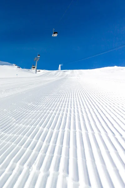 Piste de ski fraîchement damée par une journée ensoleillée — Photo