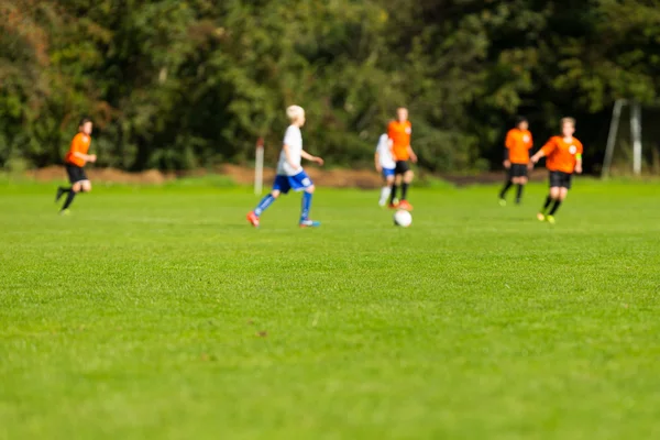 Blurred soccer players on green pitch — Stock Photo, Image