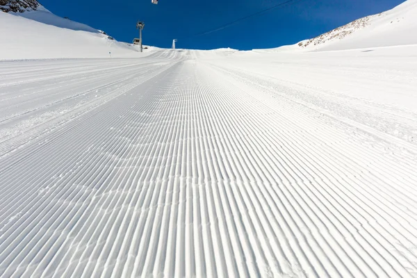 Piste de ski fraîchement damée par une journée ensoleillée — Photo