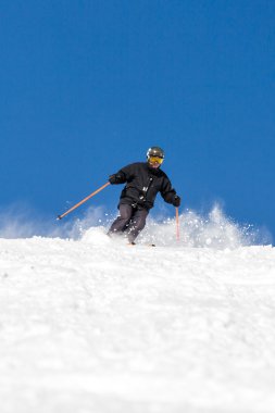 Kayakçı yamaçta kayak yapıyor.