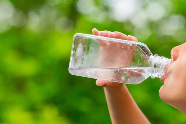 Child drinking clean tap water from transparent plastic bottle — Stock Photo, Image