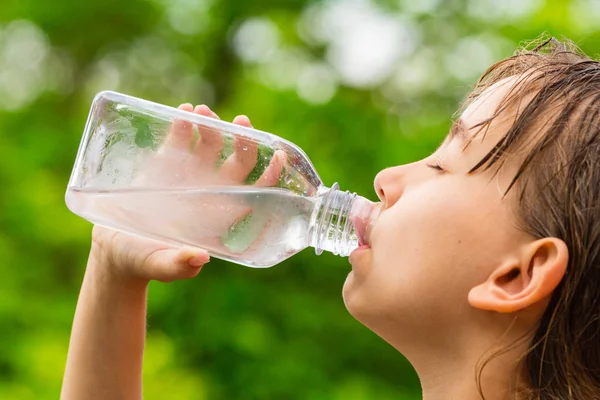 Girl drinking clean tap water from transparent plastic bottle Stock Image