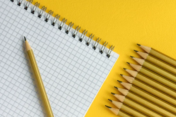 Simple Pencils Notebook Cage Close Yellow Background Top View — Stock Photo, Image