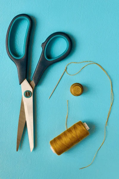 青色背景上的剪子 针和顶针 — 图库照片
