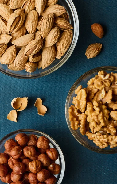 Nueces Cuencos Cristal Sobre Fondo Azul Dieta Nutrición Deportiva Vista —  Fotos de Stock