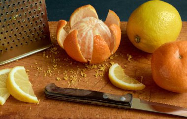 Mandalina meyvesi ve tahtanın üzerinde limon dilimleri, sığ tarla derinliği