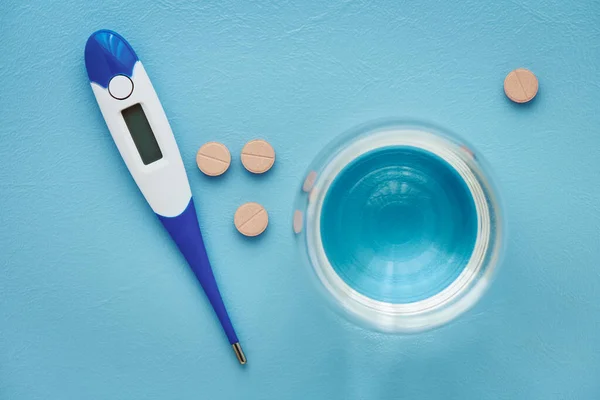 Pills Thermometer Glass Water Blue Background Top View Shallow Depth — Foto de Stock