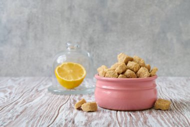 Pembe seramik kavanozda rafine edilmemiş kahverengi şeker yığını, sığ alan derinliği